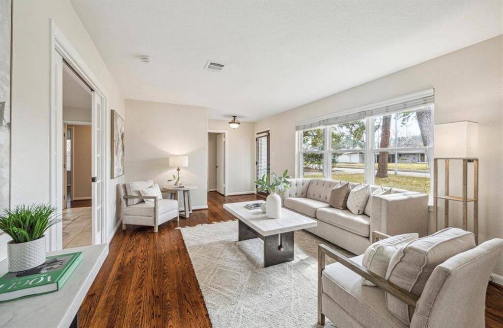 Living room area with natural lighting and open flloor plan to both study & dining area
