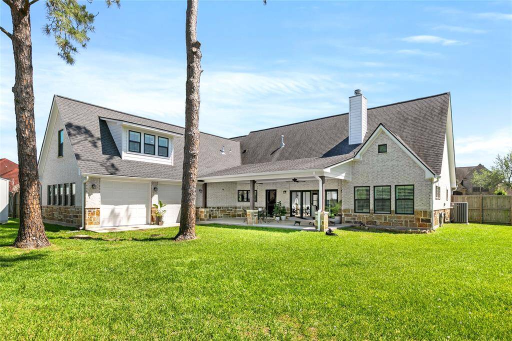 Large covered back porch overlooking spacious backyard with mature trees.