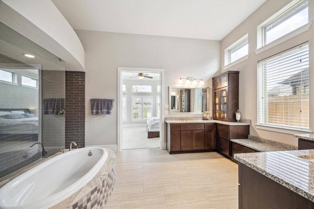 This private retreat offers the ultimate spa-like experience right at home. Featuring abundant storage, a luxurious soaking tub, and a stunning Greek walk-in shower with frameless glass and exquisite tile work, this serene space may just become your favorite escape.