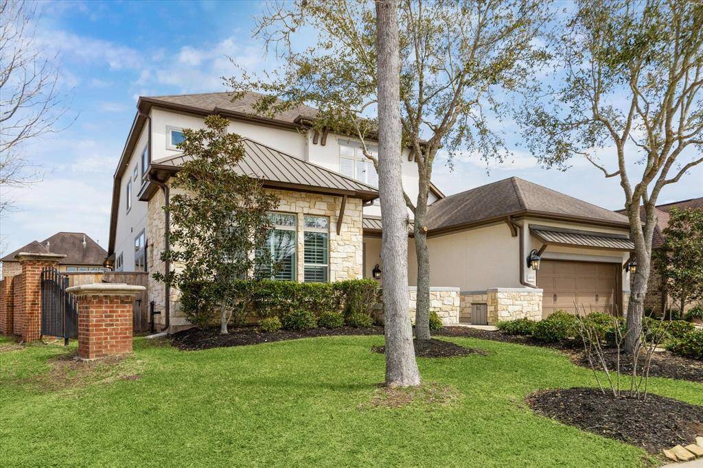 This stunning former David Weekley model home boasts undeniable curb appeal with its elegant stone and stucco exterior, manicured landscaping, and charming architectural details. A courtyard gated entry and beautiful coach lighting add to the welcoming first impression.