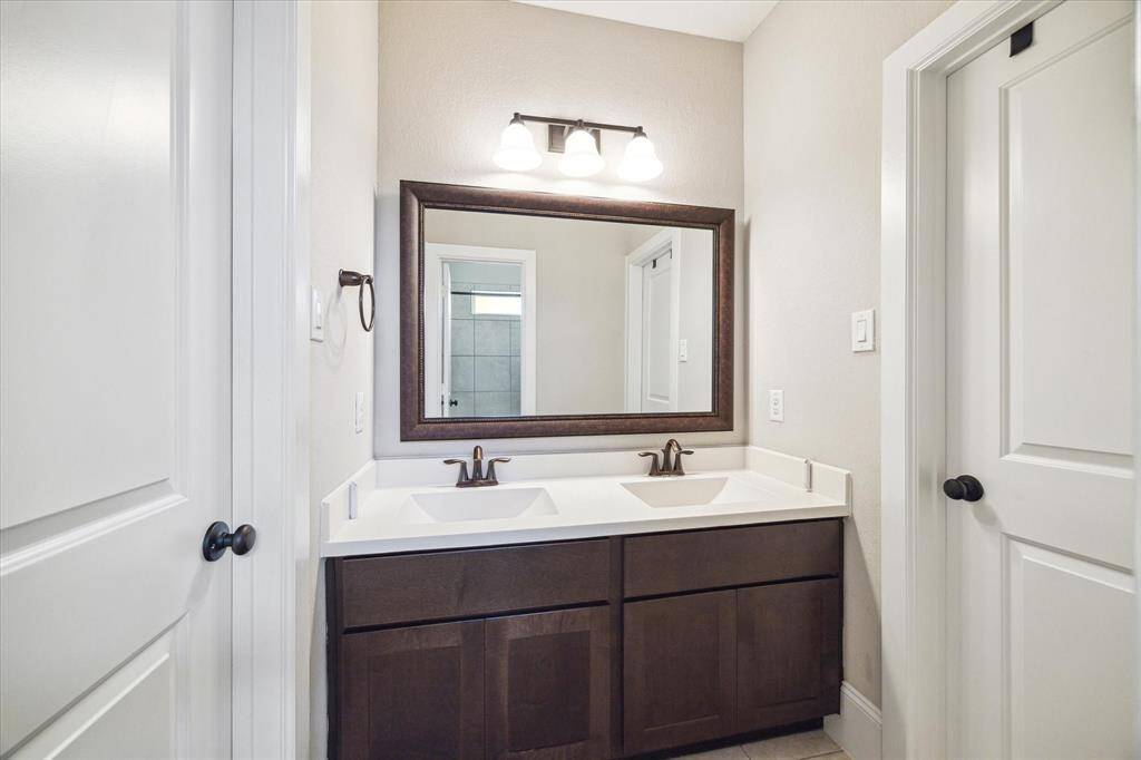 Each guest suite enjoys ensuite access to this thoughtfully designed vanity area with dual sinks, making it easy to share. A separate water closet with a tub/shower and toilet ensures privacy and helps keep morning routines running smoothly.