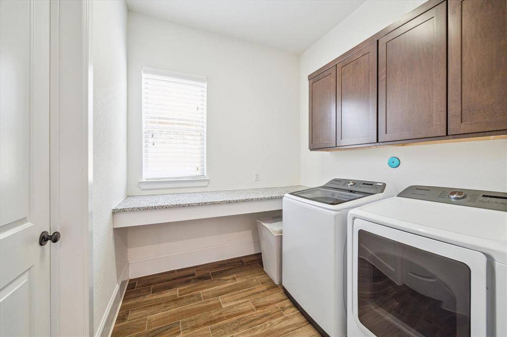 Laundry feels less like a chore in this spacious utility room, complete with a convenient folding counter and built-in cabinetry for extra storage.