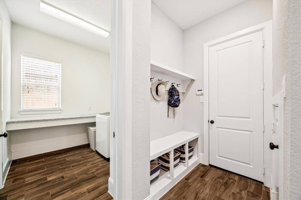 Keep everything in its place with this convenient mud area, featuring built-in shelving, cubbies, and handy hooks for jackets, hats, and backpacks—perfect for staying organized on busy days.