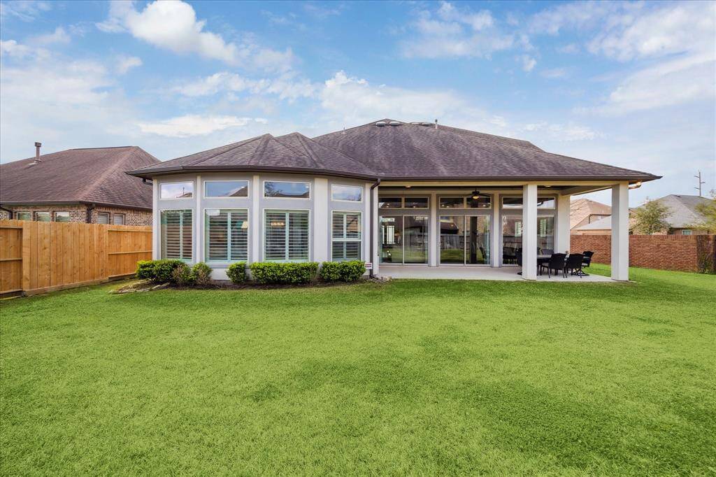 This sprawling fenced lawn, with a sprinkler system for easy care, offers the perfect space for barefoot fun!