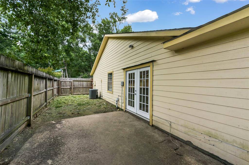 Concrete patio on side with double French doors