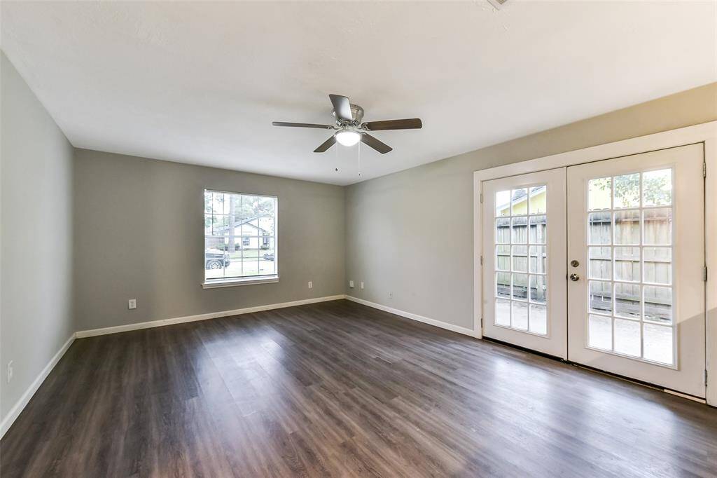 Living room with vinyl plank floors, ceiling fam and double French doors