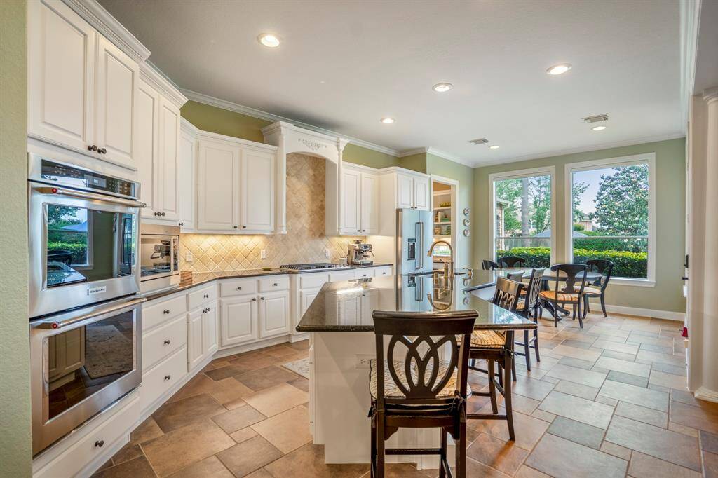 The Chef in your family is going to love this special kitchen with natural tones, huge island and and abundance of countertop space, double ovens, a gas stove top and tons of drawers, upper and lower cabinets.