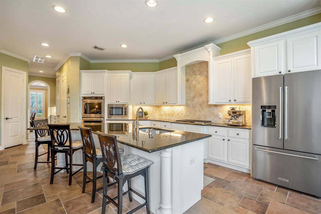This kitchen is all about easy and effortless cooking and entertaining, offering Stainless Steel appliances, tons of cabinetry, an oversized island with sink as well as tons of natural light.