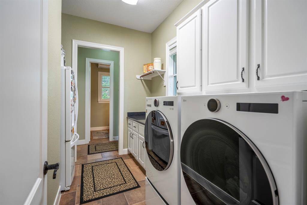 The large laundry in this home offers tons of additional storage, as well as a folding area, and soaking sink.
