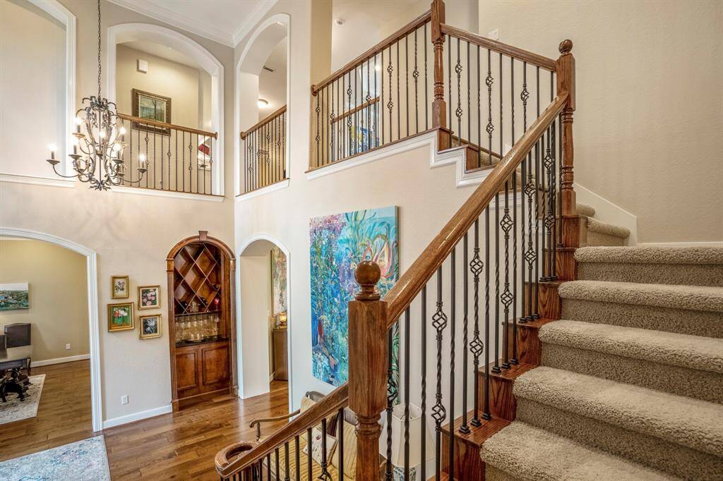 Leading to the second floor living you will find this beautifully ornate wrought iron spindle staircase with wood hand rails and thread with neutral toned carpeting.