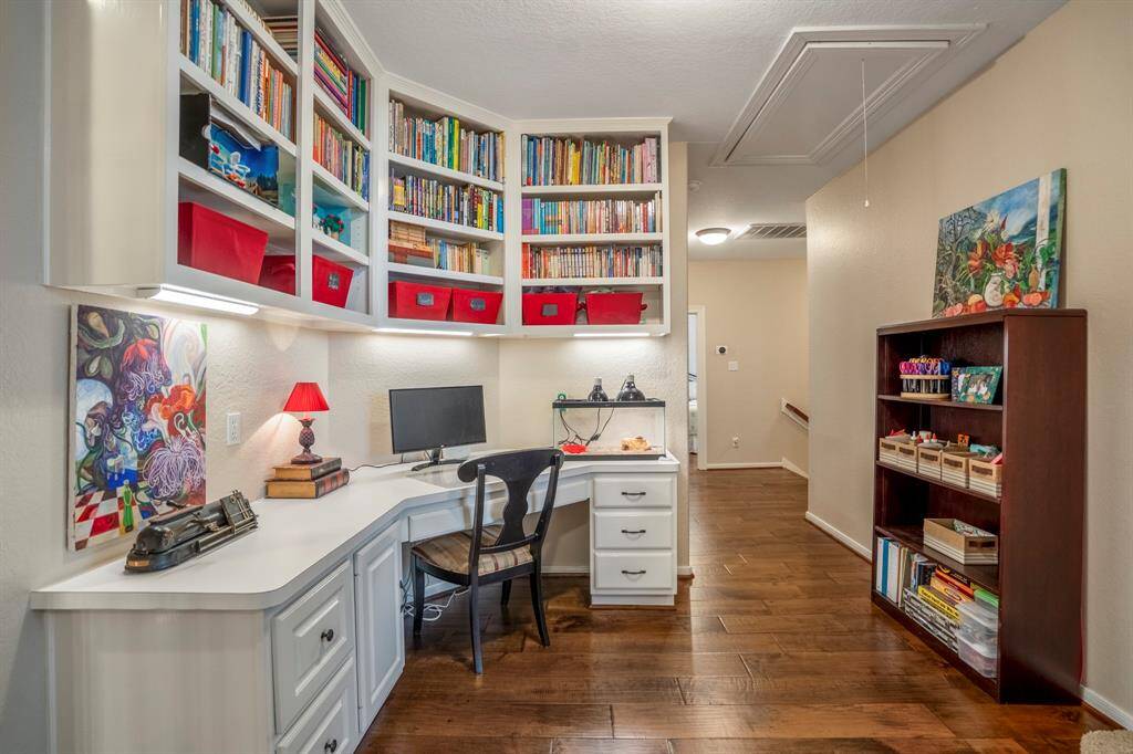An additional study / homework / craft area upstairs offers a convenient built-in desk area with overhead lighting and custom bookshelves above.