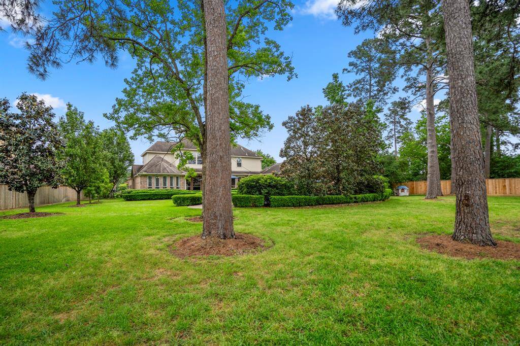A view of the back of the home from the wrought iron fence on the border of the property and the golf course, you can see it is private and especially the pool area.