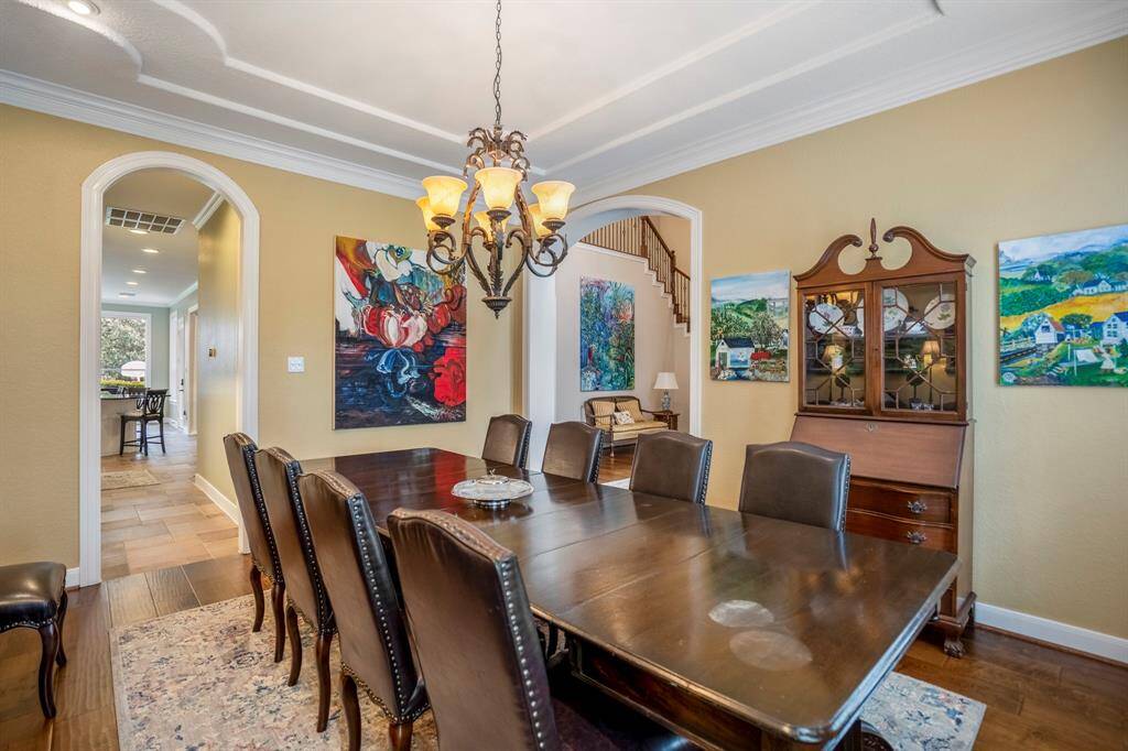 The dining room is large enough to accomodate large furniture as seen in this photo, as well as having the beautiful gleaming wood floors and framed arched doorways.