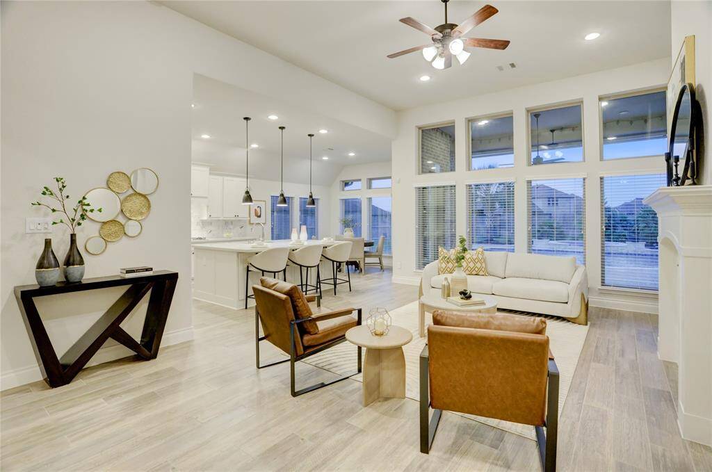 Spacious and open-concept living area filled with natural light from the wall of windows. Seamlessly flows into the kitchen and dining, making it ideal for gatherings.