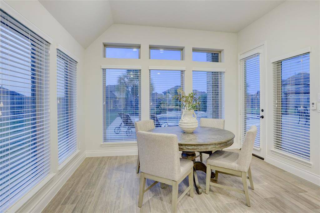 A charming breakfast area surrounded by windows with backyard views. Functional layout with plenty of counter and cabinet space.