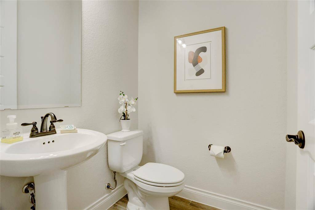 This charming powder bath offers a clean, modern aesthetic with a classic pedestal sink, stylish hardware, and neutral tones. Perfectly positioned for guests, it adds both function and style to your home.
