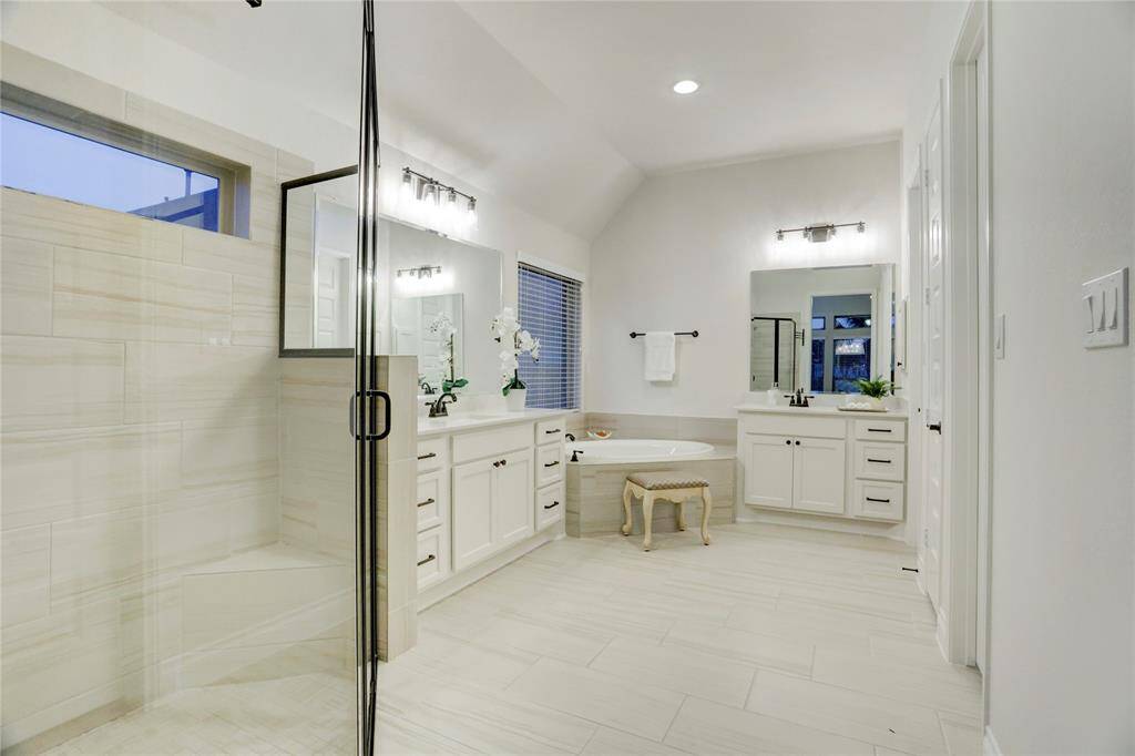 Indulge in spa-like luxury with this expansive en-suite bath featuring dual vanities, a relaxing soaking tub, and an oversized glass-enclosed shower. The layout is perfect for both daily routines and peaceful unwinding.Indulge in spa-like luxury with this expansive en-suite bath featuring dual vanities, a relaxing soaking tub, and an oversized glass-enclosed shower. The layout is perfect for both daily routines and peaceful unwinding.