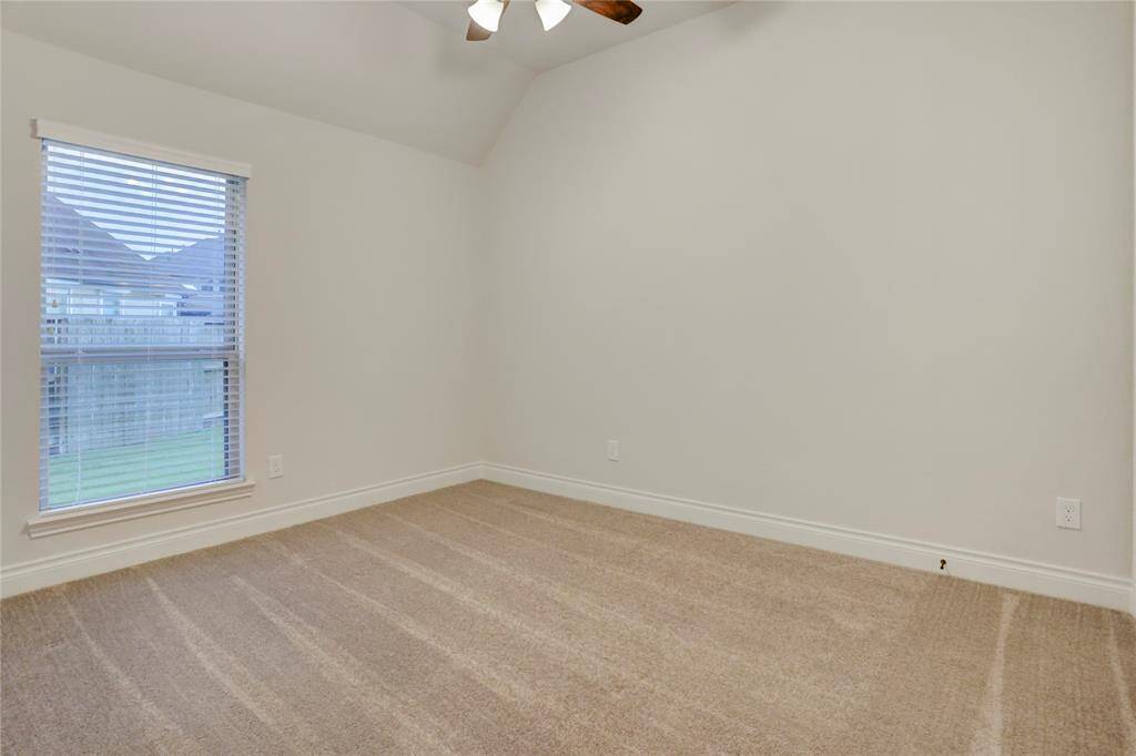This cozy secondary bedroom offers the perfect retreat with soft neutral carpet, a large window that fills the space with natural light, and enough room to comfortably fit a queen-sized bed. A spacious walk-in closet adds convenience and storage, making this room ideal for guests and/or kids.