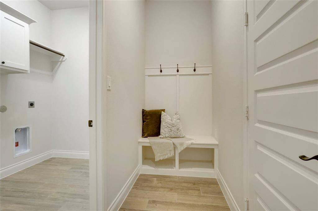 This laundry area offers ample space as well as a hanging rack. The mud room is ideal for organizing backpacks, shoes, and daily essentials right as you enter the home.