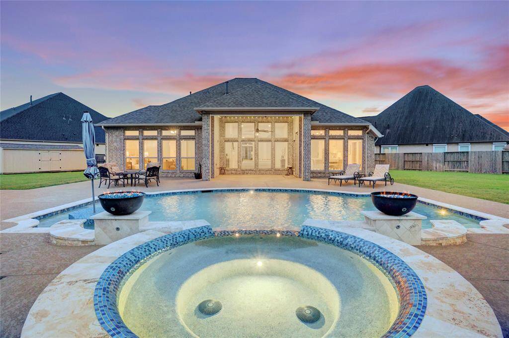 Step into your private backyard oasis featuring a sparkling pool and elevated spa, perfectly accented by dramatic fire bowls that create a resort-like ambiance at sunset. Whether you're enjoying a relaxing swim or hosting a party, this setting delivers the ultimate WOW factor.