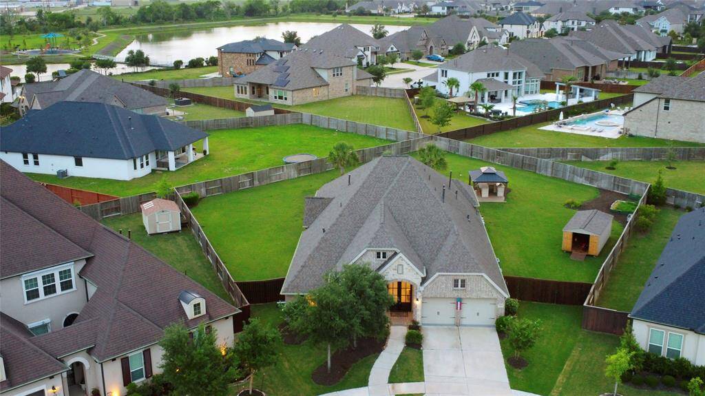 From this stunning aerial view, take in the full scope of your future 20,000+ sq. ft. lot an entertainer’s paradise and private retreat all in one. The expansive backyard offers a beautifully designed pool and spa, with eye-catching fire bowls, a charming gazebo with twinkling lights and a fully equipped outdoor kitchen. A large storage shed offers practical space for tools and equipment, while a whole-home Generac generator adds peace of mind and security.