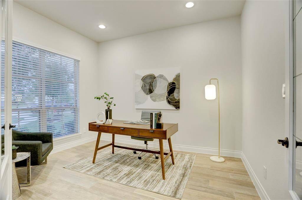 This private study offers a serene workspace with large windows for natural light, sleek wood-look tile flooring, and French doors for privacy—perfect for remote work or quiet focus.