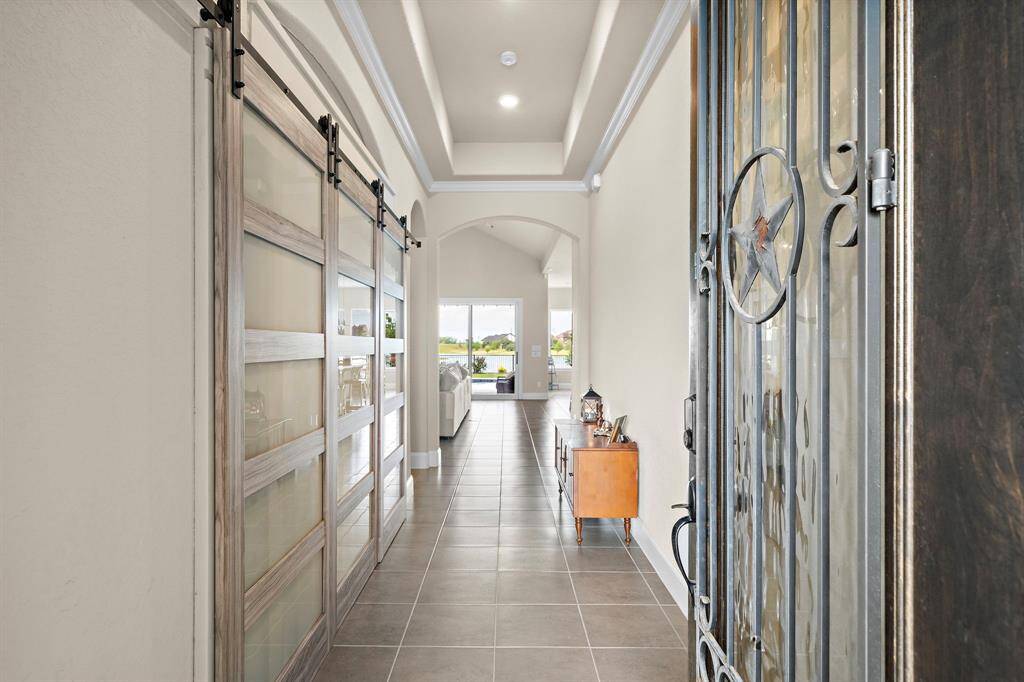 Entry way of home with office space to the left, secondary bedrooms and bathroom to the right, and living spaces straight ahead.
