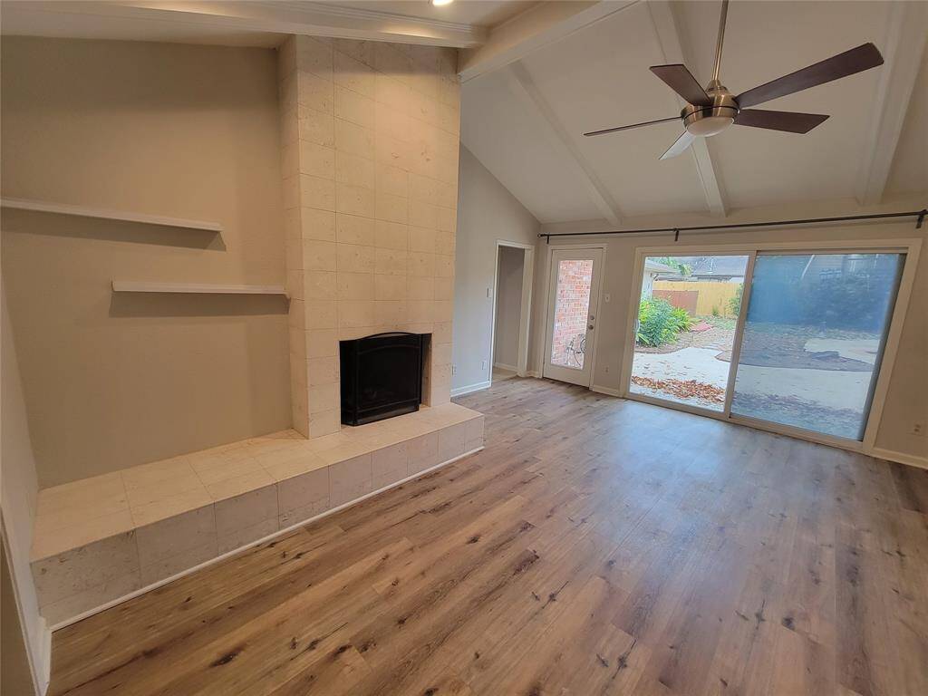A wall of windows in your incredible living space looks out onto your generous backyard; while inside, the fireplace is nicely encased in floor-to-ceiling stone, with unique shelving for artistic display.