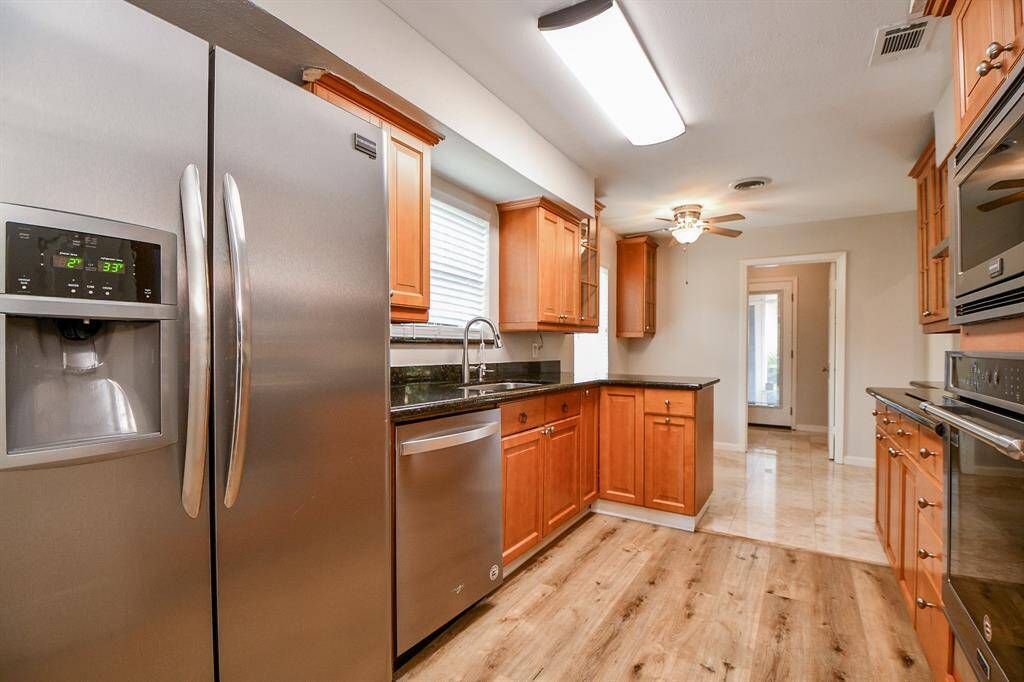 Compact and completely workable, honey colored cabinetry defines the traditional sophistication of gorgeous storage options, with gleaming stainless steel appliances to serve!
