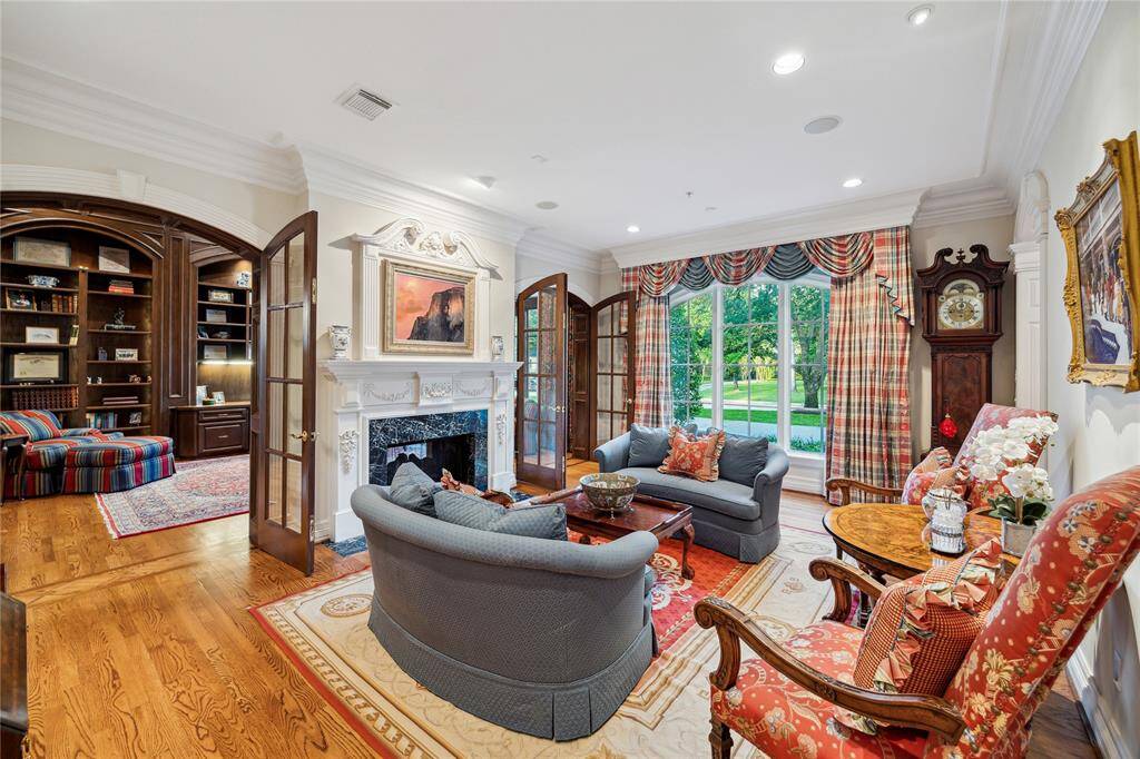 Sophistication and privacy between the living room and the formal study are enhanced by a set of double doors. Discreetly hidden beneath the molding, double curtain rods add a touch of elegance.