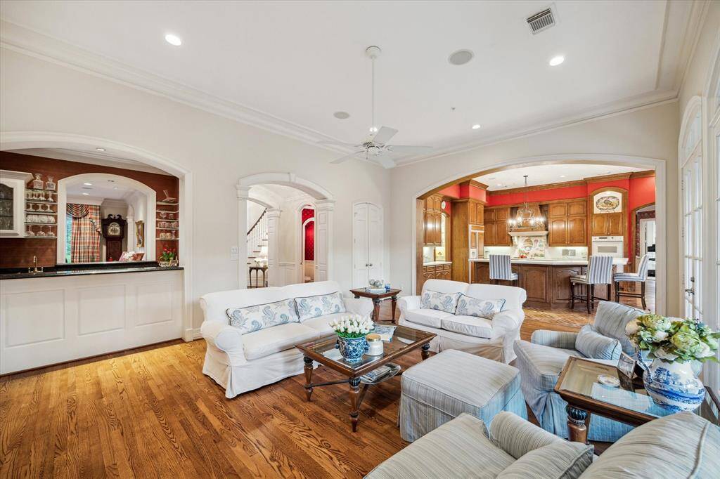 The family room, an open yet well-defined space, seamlessly connects to the double-sided bar, private guest bath, and kitchen.