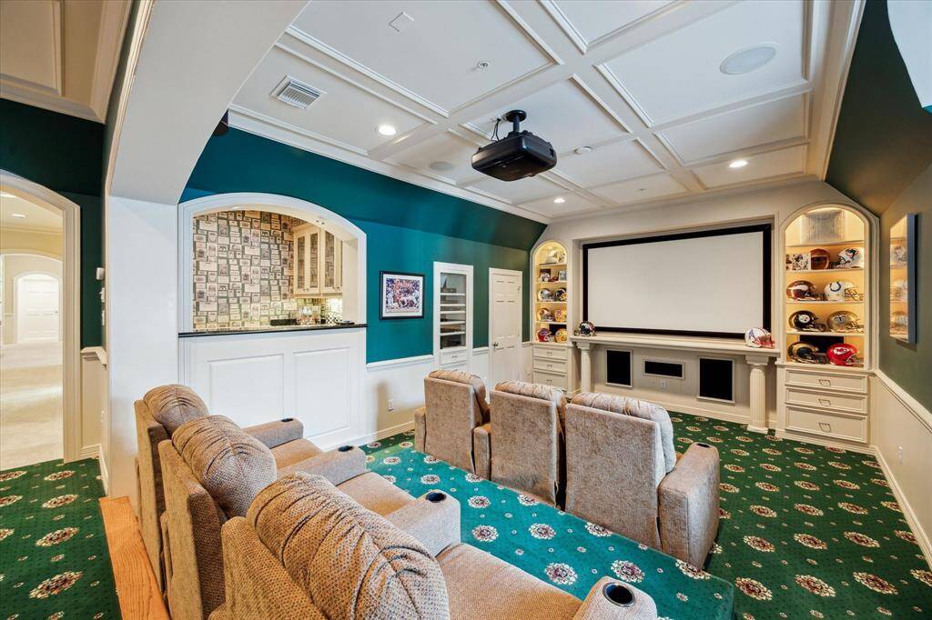 The media room boasts step-down theater seating with plush, luxurious chairs, perfect for long movie nights. Enjoy a 125" screen, illuminated display cabinets, a state-of-the-art built-in speaker system, and seamless access to the elegant secondary bar.