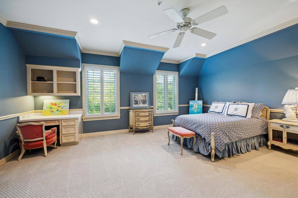 One of the four upstairs bedrooms features an en-suite bathroom, a built-in desk, and a spacious walk-in closet with elegant built-in drawers.