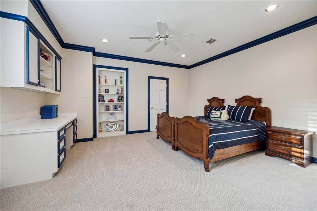 The fourth bedroom not only includes a built in desk but shelves for displaying personal items.