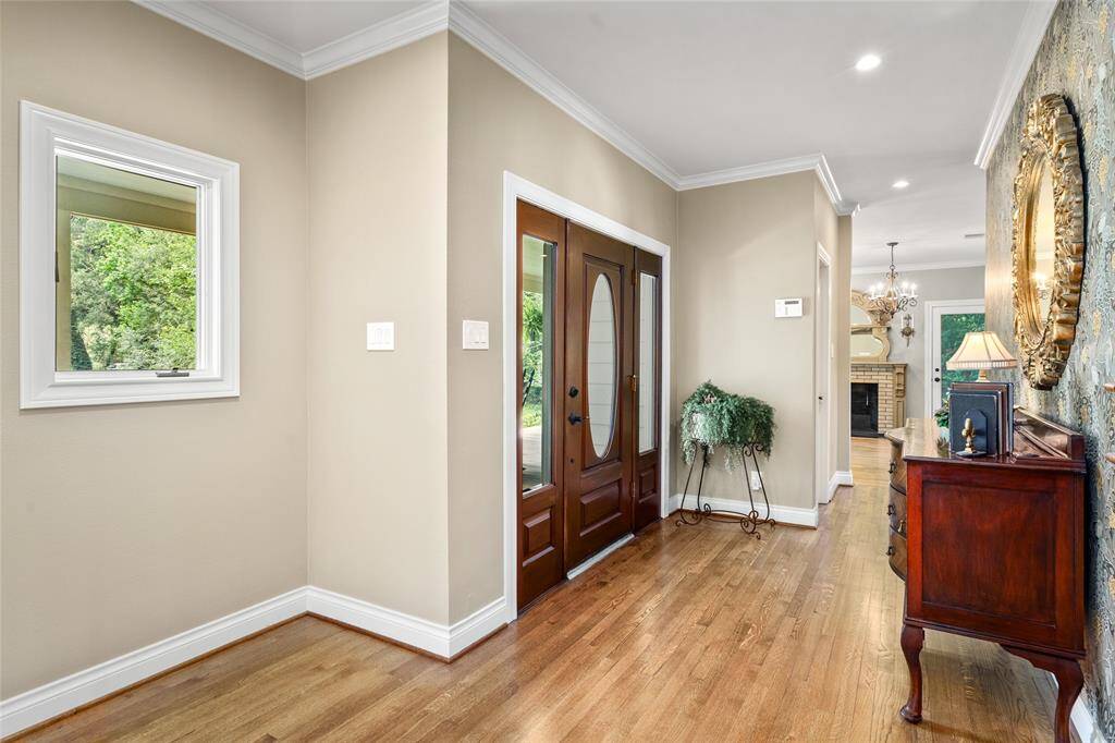 Step into a warm and inviting entryway featuring rich natural light and elegant architectural details that set the tone for the rest of the home. A hidden storage closet under the staircase adds additional storage to this beautiful space.