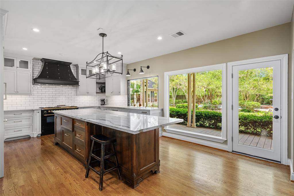 Expansive kitchen windows offer stunning views of the lush backyard, flooding the space with natural light and bringing the beauty of the outdoors right inside.
