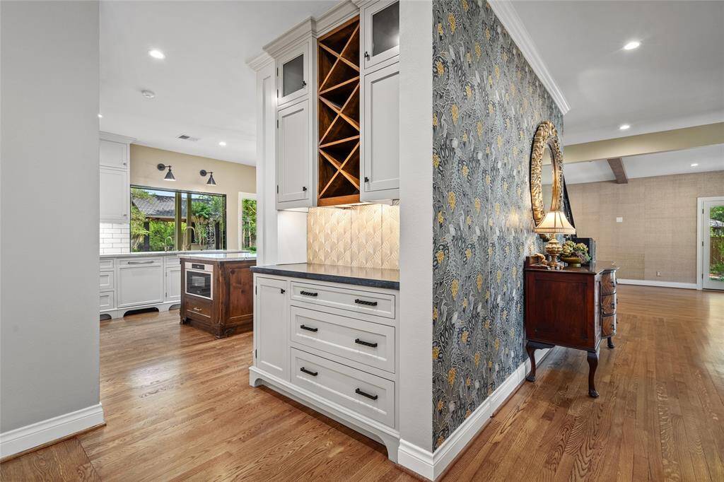 Stylish dry bar just off the kitchen perfect for entertaining, featuring sleek cabinetry, under cabinet lighting, and a functional layout—ideal for mixing drinks or serving guests in the heart of the home.