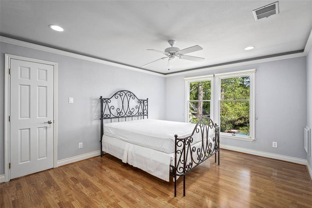 Spacious secondary bedroom with a large walk-in closet and serene views overlooking the beautifully landscaped backyard and pool—peaceful and private.