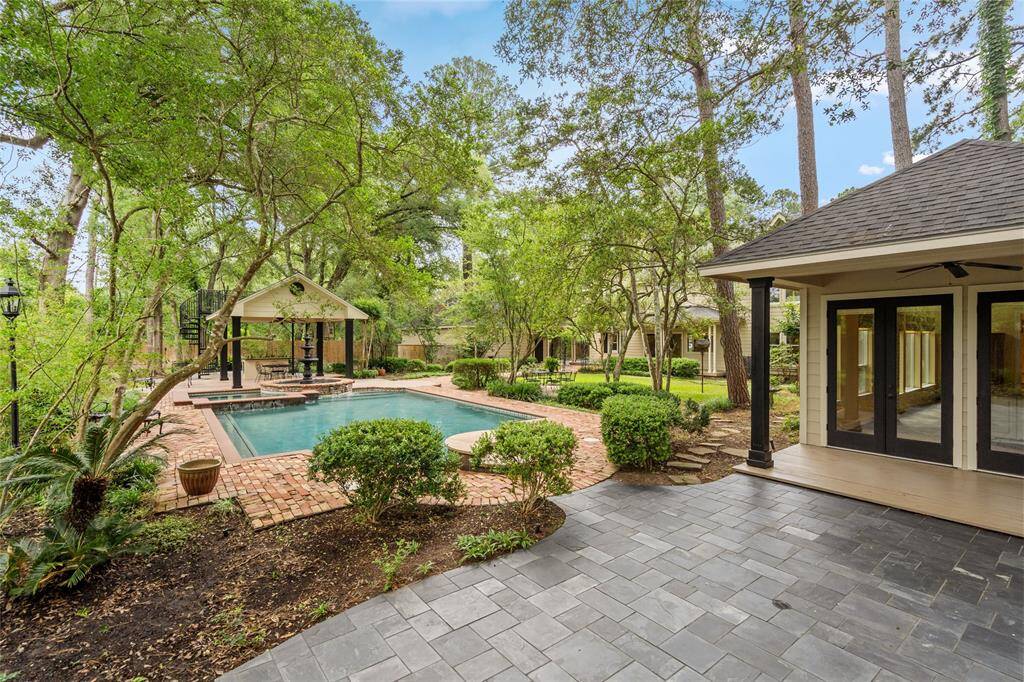 Charming patio area that seamlessly connects to the guest house, offering a perfect outdoor space for relaxation or entertaining. Surrounded by lush landscaping, it provides a tranquil pathway to the fully-equipped guest retreat.