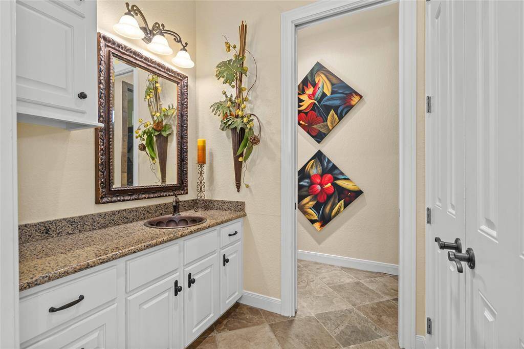 Modern bathroom in the guest house featuring a sleek frameless shower, contemporary fixtures, and clean, stylish finishes. The space also includes convenient in-unit laundry, offering comfort and functionality for guests or extended stays.