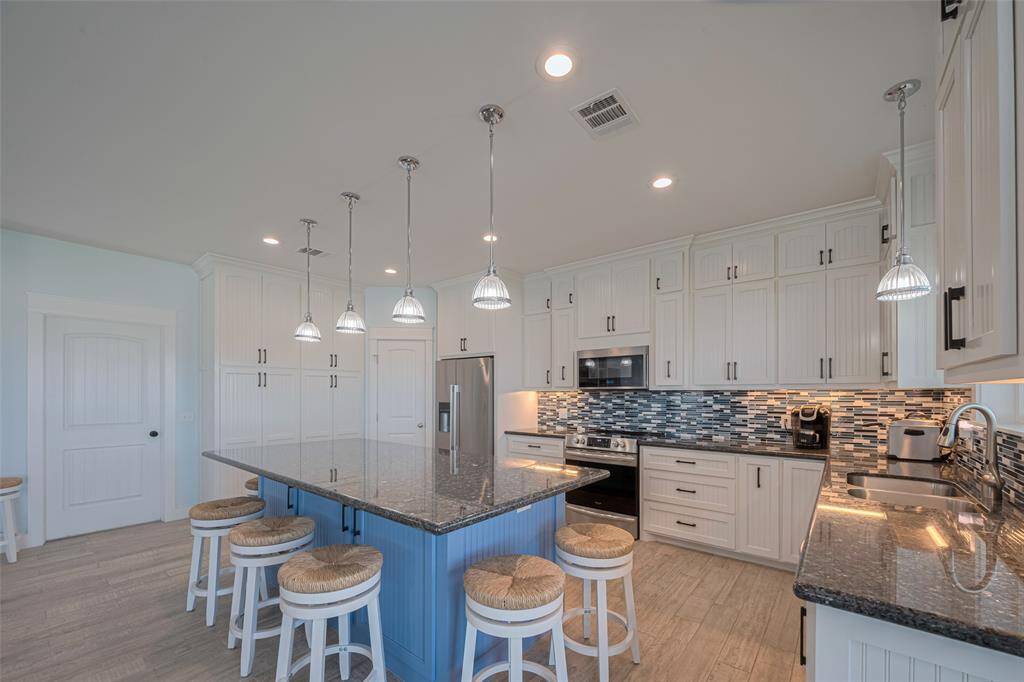 Beautiful kitchen with island, pantry, and built-ins for extra storage.