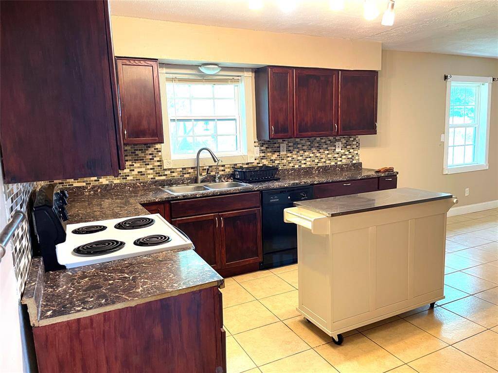Kitchen with wood cabinetry and included appliances.