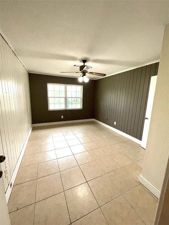 Bedroom with ceiling fan and tile flooring.