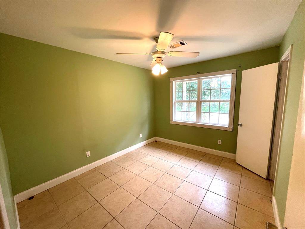 Bedroom with accent wall and ceiling fan.