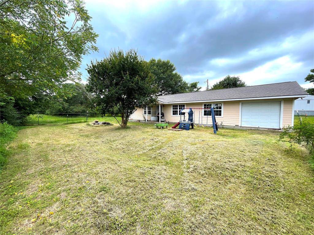 Back exterior view – large yard with privacy and mature trees.