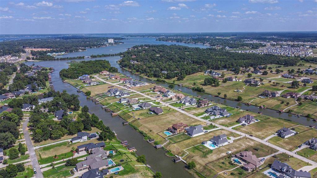 This aerial photo showcases a waterfront residential community with spacious properties, some with private docks, offering scenic views and access to the waterways. The neighborhood is situated near a larger body of water, suggesting potential for aquatic activities and a tranquil living environment.