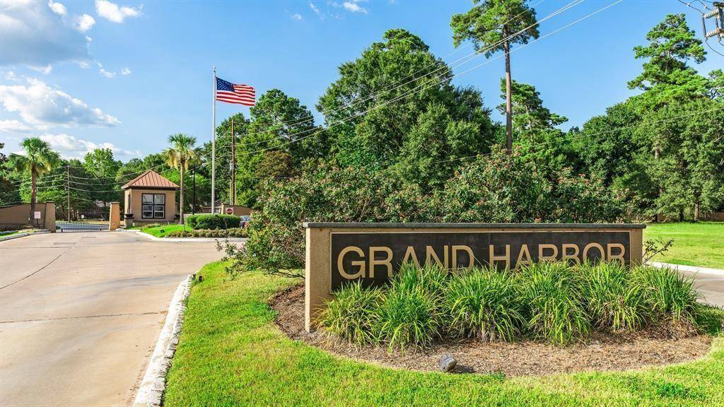 This photo showcases the entrance to the Grand Harbor community, featuring a well-maintained sign amidst lush landscaping, a guardhouse.