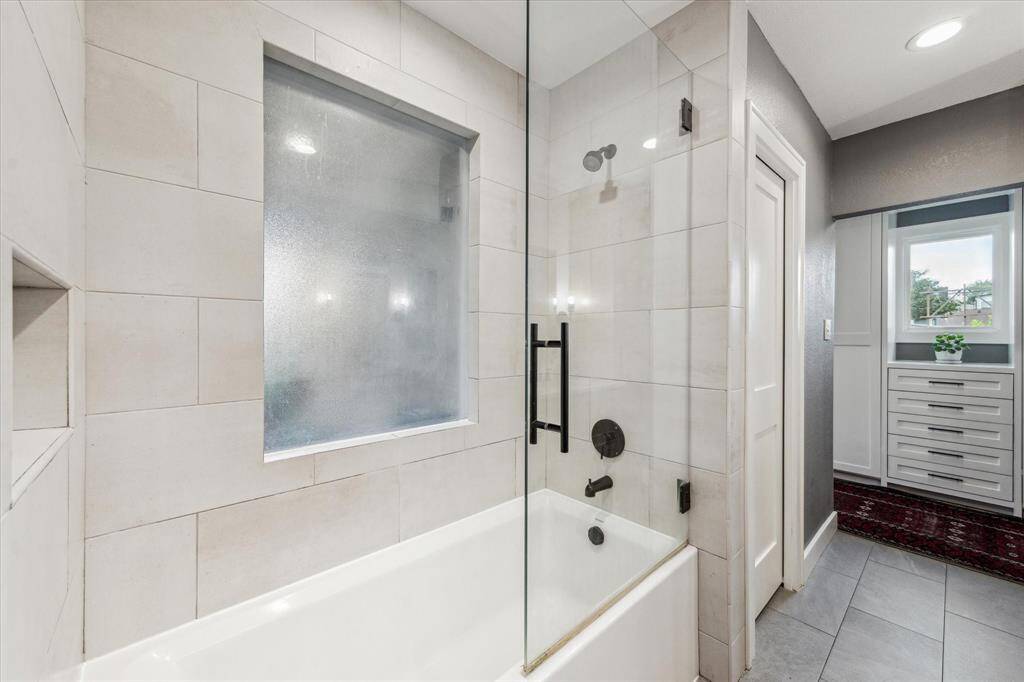 A shower/tub combo with a sleek glass enclosure completes the ensuite bath.