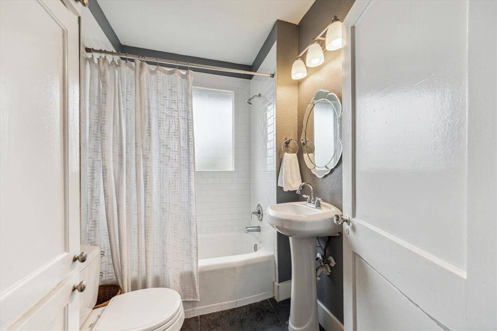 Full bathroom for the secondary bedrooms with a shower/tub combo and pedestal sink.