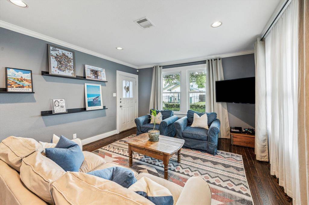 The living room is wrapped in windows on two sides, filling the space with an abundance of natural light.